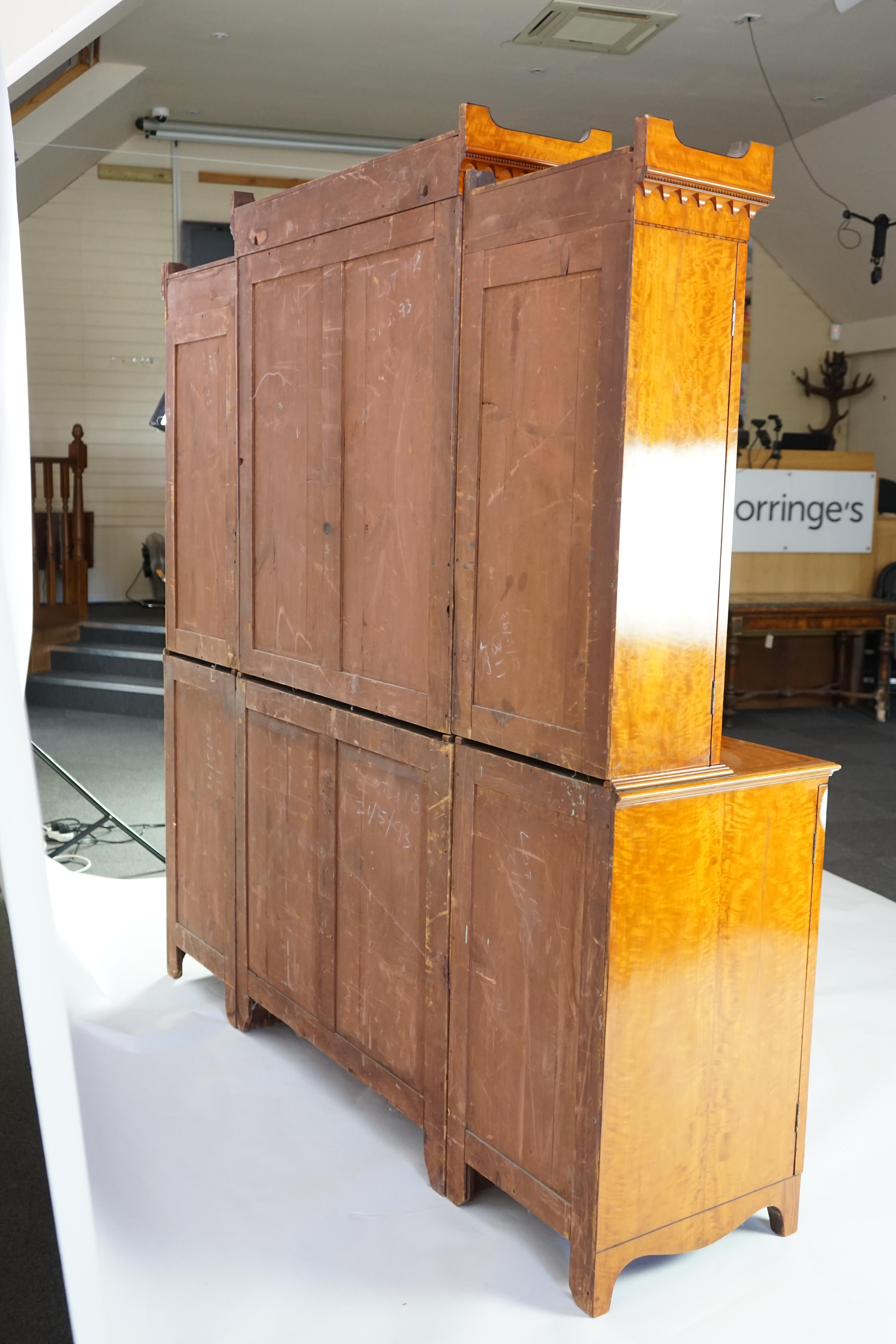 A Sheraton revival ebony strung satinwood breakfront secretaire bookcase